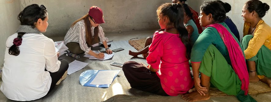 A researcher explaining her research to locals in Nepal